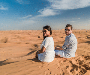 Tourists capturing memories in the desert, experiencing warm hospitality in Dubai safari.